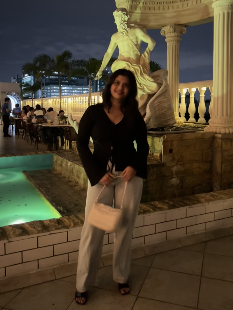 “Harshita posing near a statue in a night setting for a marketing portfolio website.”